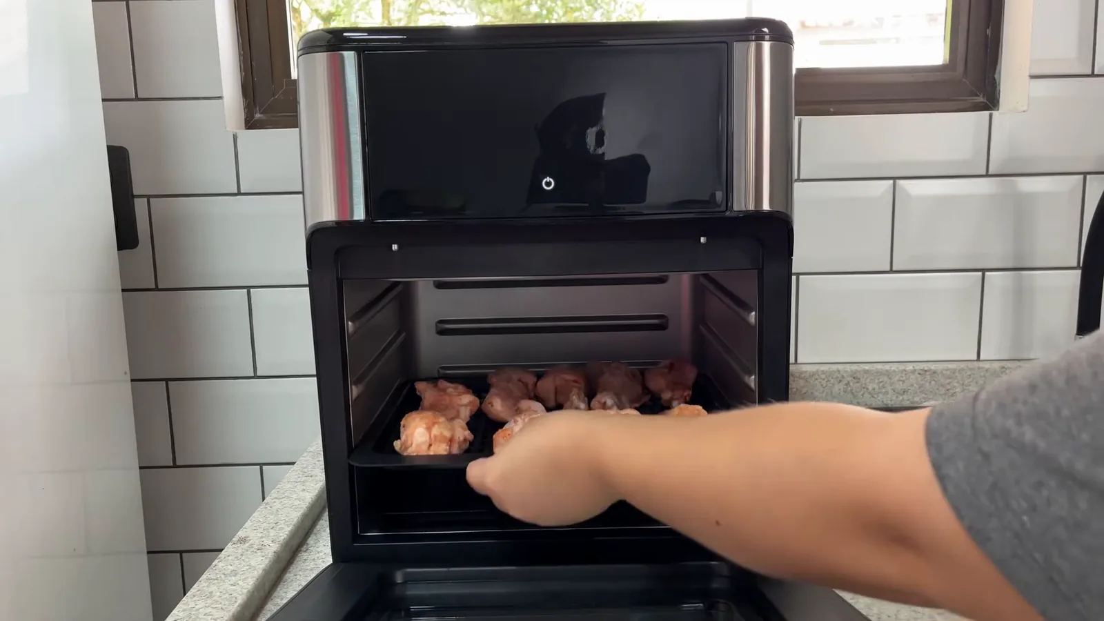 Assadeira com batatas sendo posicionada dentro da air fryer oven