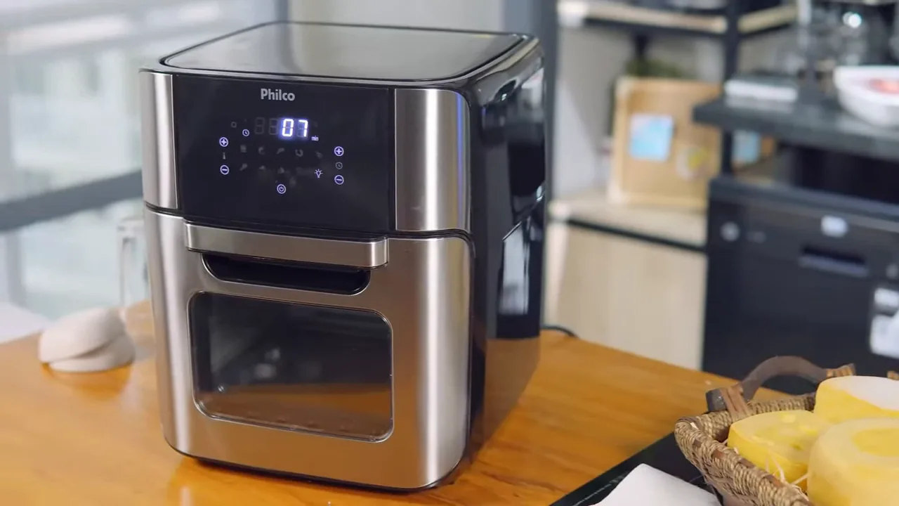 Air fryer Philco Oven ligada preparando alimentos na bancada da cozinha