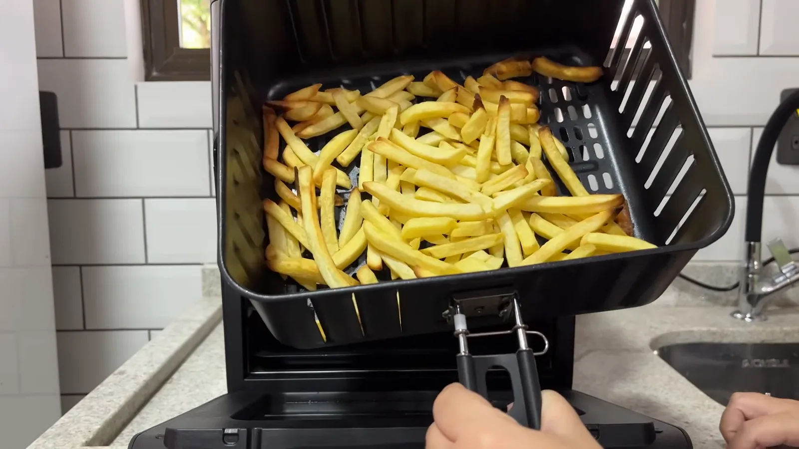 Cesto da air fryer oven com batatas fritas douradas e crocantes
