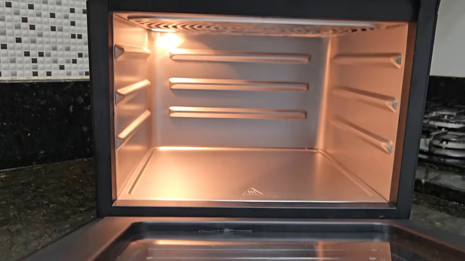Espaço interno da Air Fryer Mondial iluminado pela luz embutida