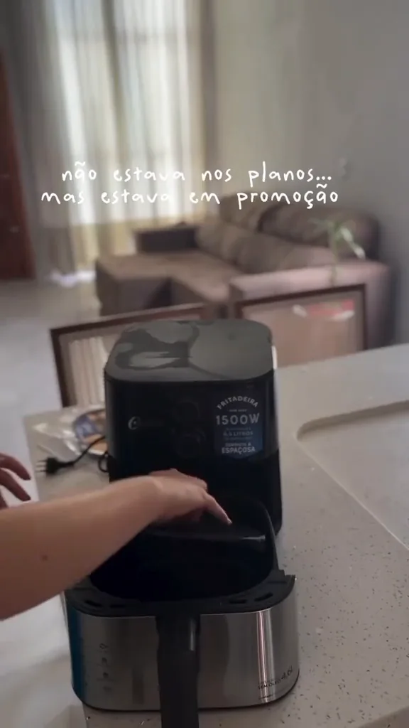 Grelha removível sendo encaixada no cesto da air fryer Oster