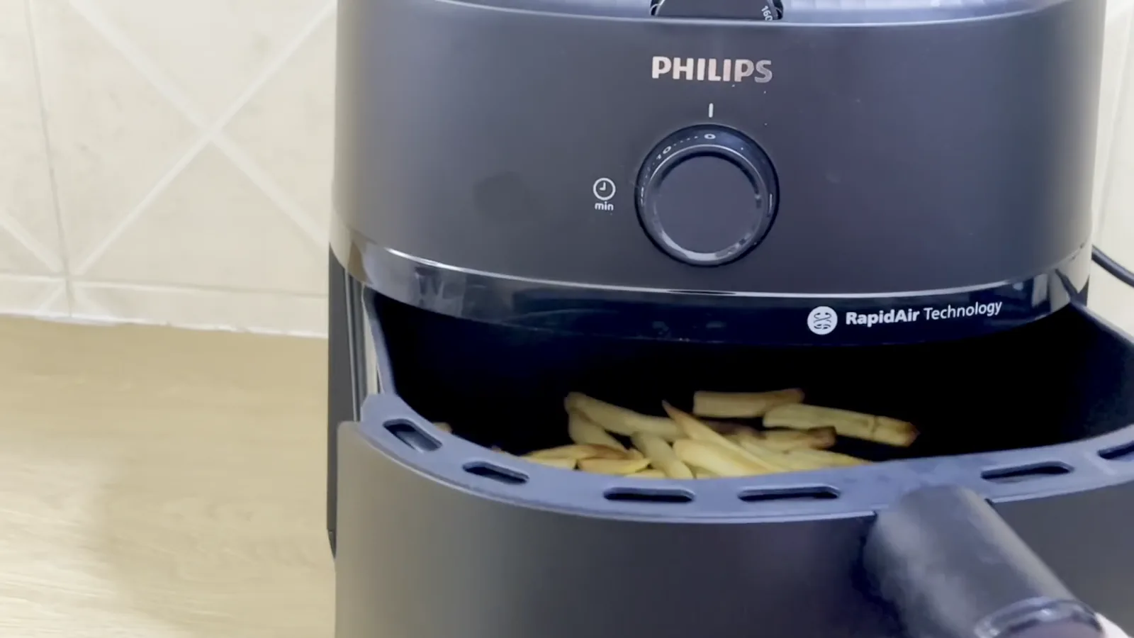Gaveta aberta exibindo batatas fritas douradas na air fryer Philips