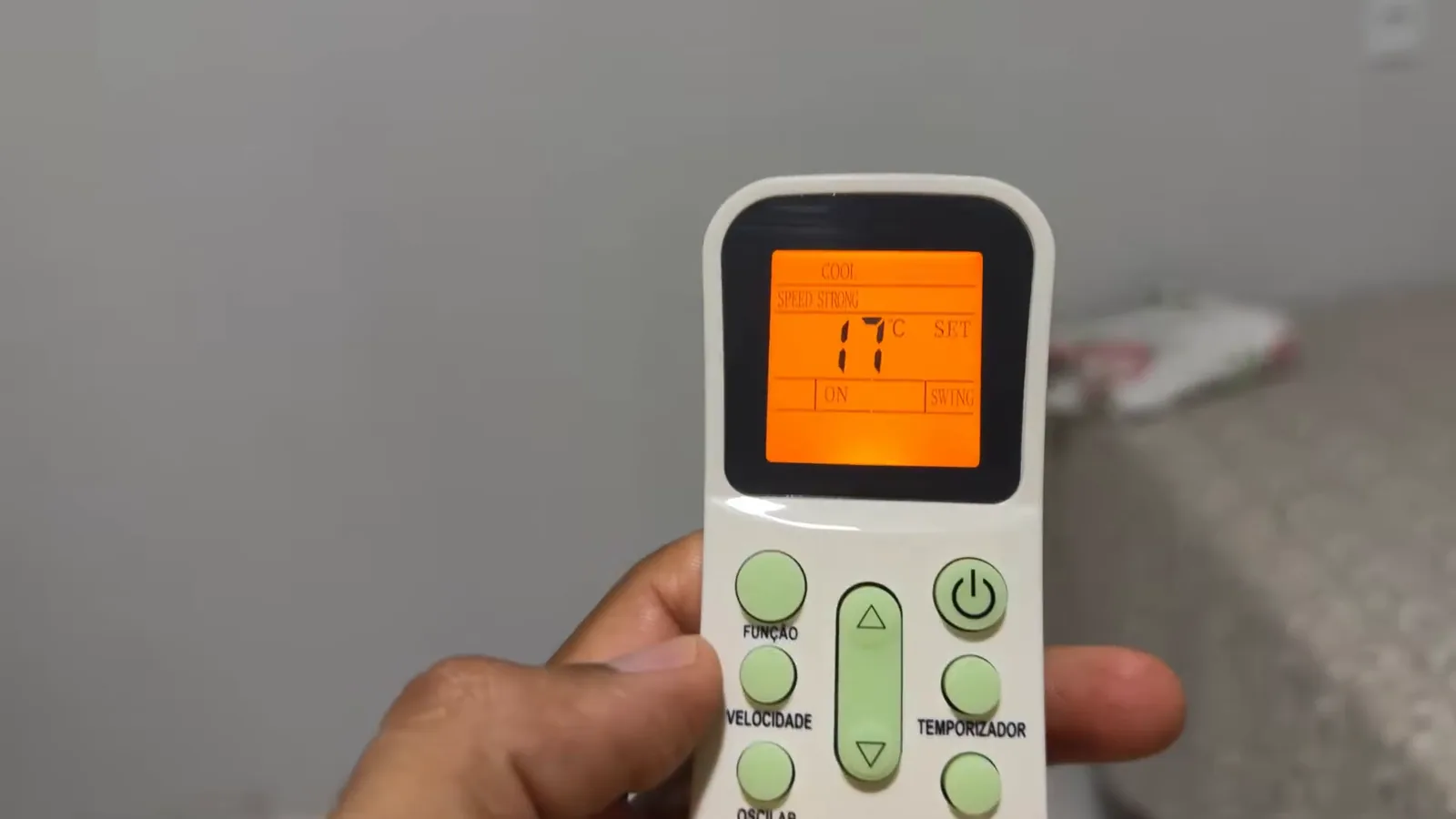 Controle remoto com visor iluminado configurando temperatura do ar-condicionado Elgin