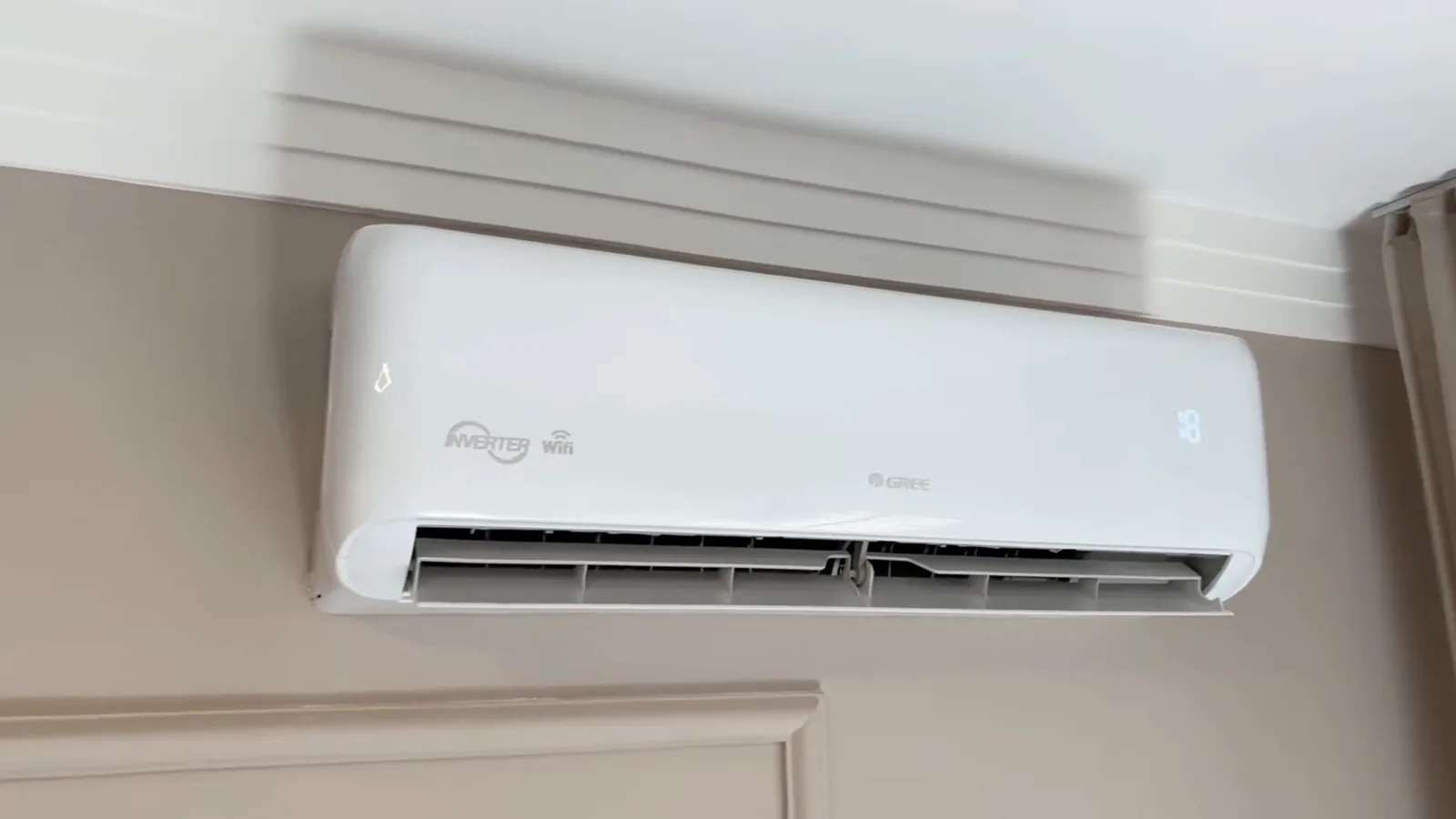 Evaporadora do ar-condicionado Gree instalada na parede do quarto em funcionamento