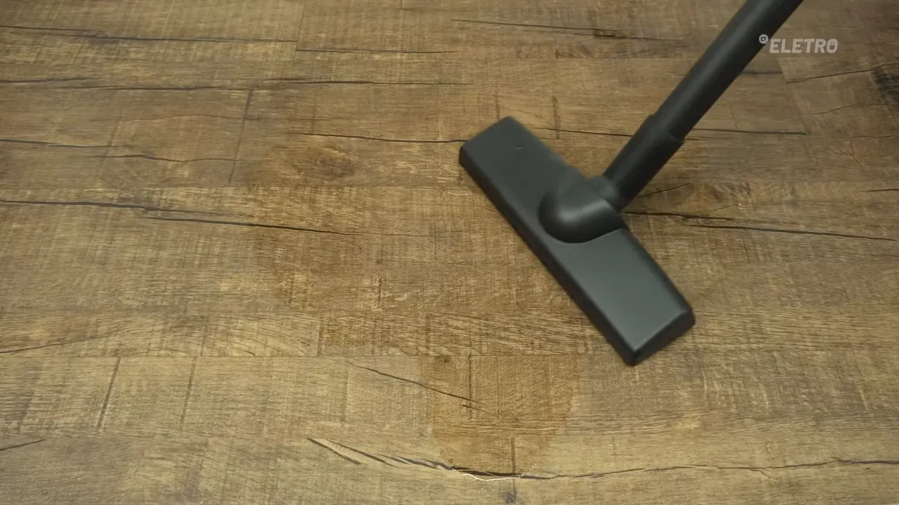 Bocal do aspirador sugando poça de água no piso
