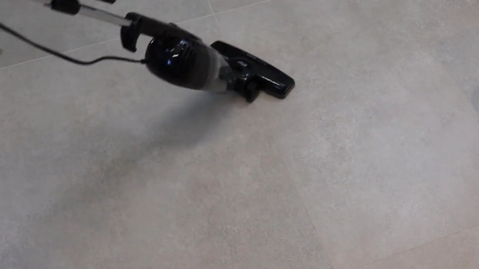 Aspirador de pó vertical sendo utilizado em piso de porcelanato