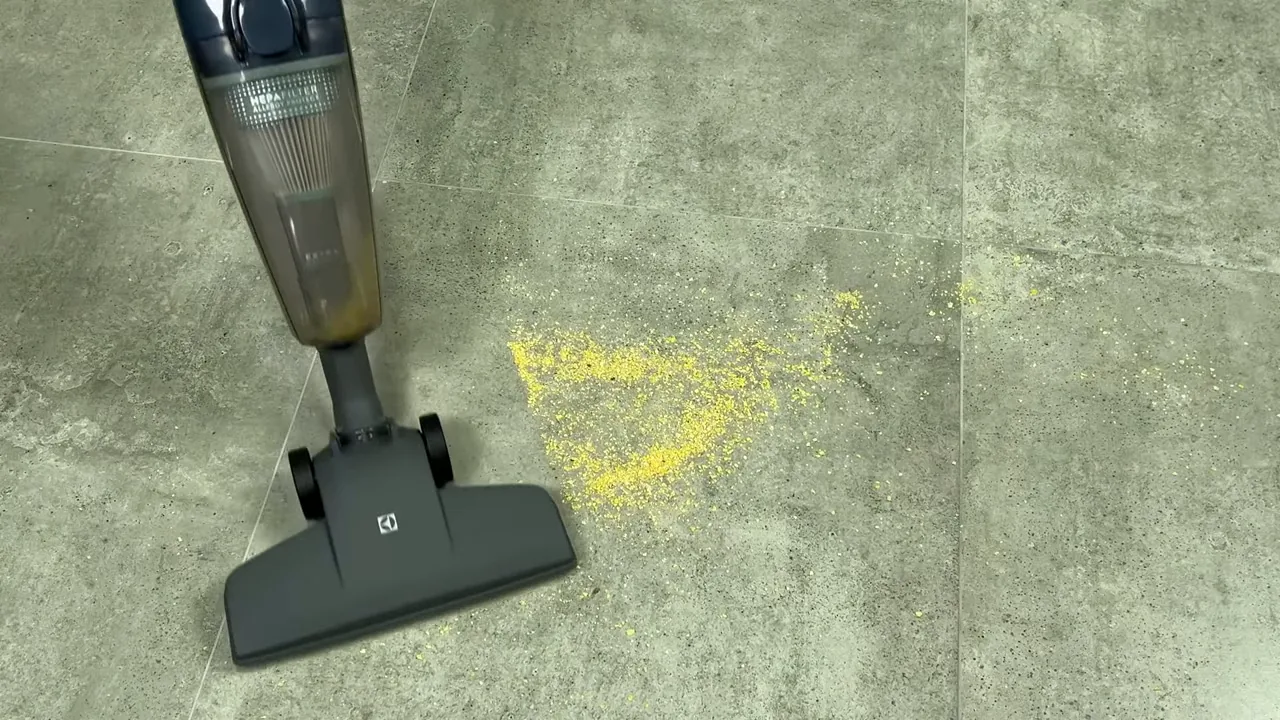 Aspirador vertical realizando a sucção rápida de sujeira em piso frio