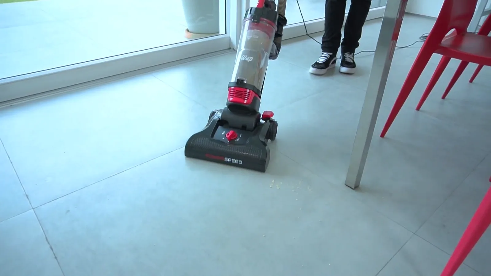 Aspirador de pó vertical limpando sujeiras no piso liso