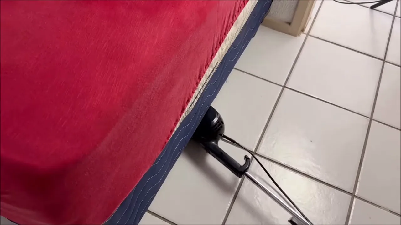 Aspirador vertical manobrando sob a cama com bocal articulado