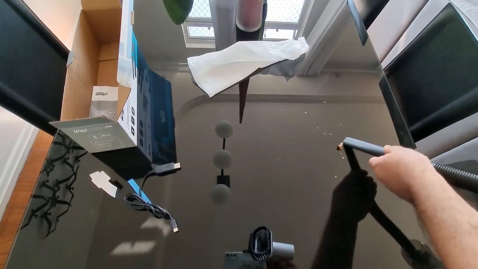 Bico com mangueira flexível aspirando resíduos sobre a mesa