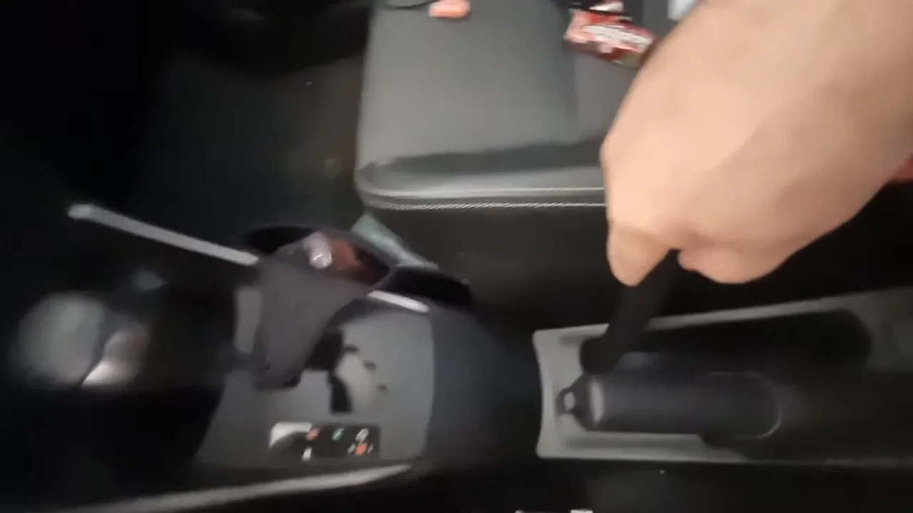 Bico extensor do aspirador alcançando frestas no console do carro