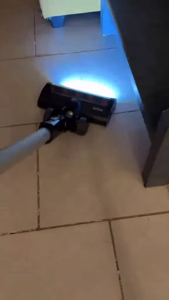 Aspirador vertical limpando piso cerâmico com bocal de LED