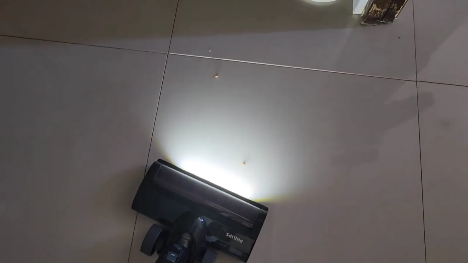 Bocal com luz LED aspira sujeiras em piso cerâmico