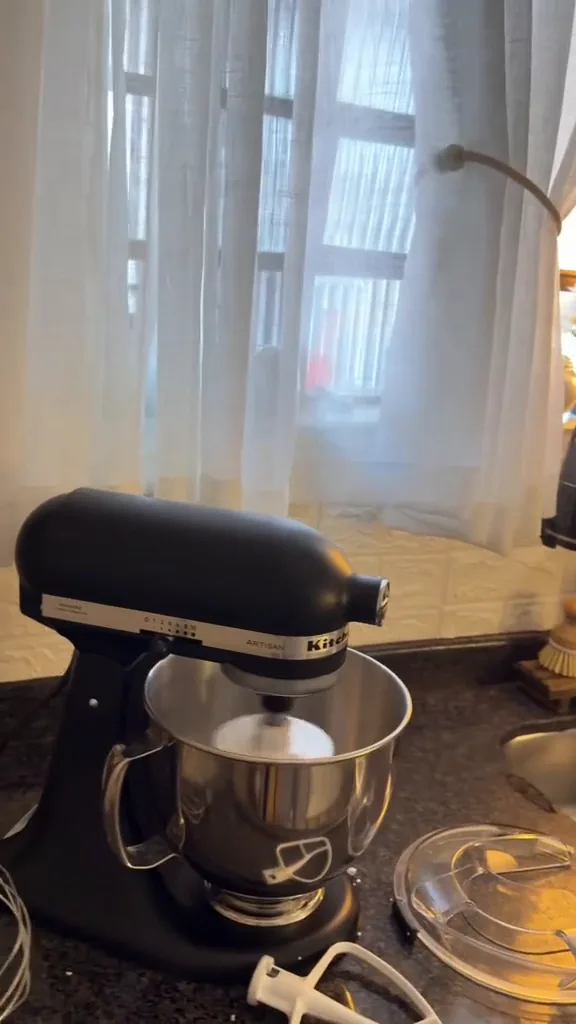 Batedeira planetária KitchenAid Artisan ligada em funcionamento na bancada da cozinha