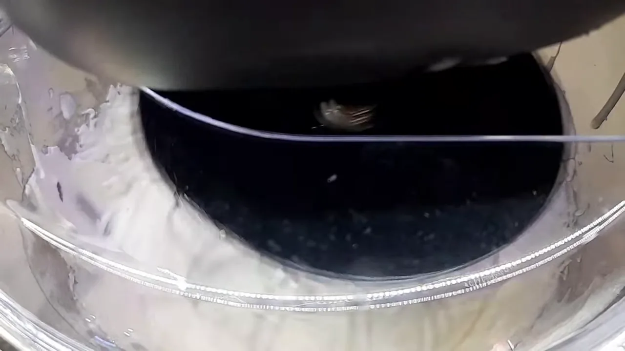 Batedor da batedeira planetária batendo creme chantilly em ponto firme