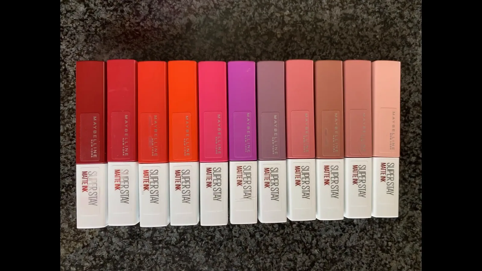Frascos do batom líquido Maybelline SuperStay Matte Ink alinhados na bancada