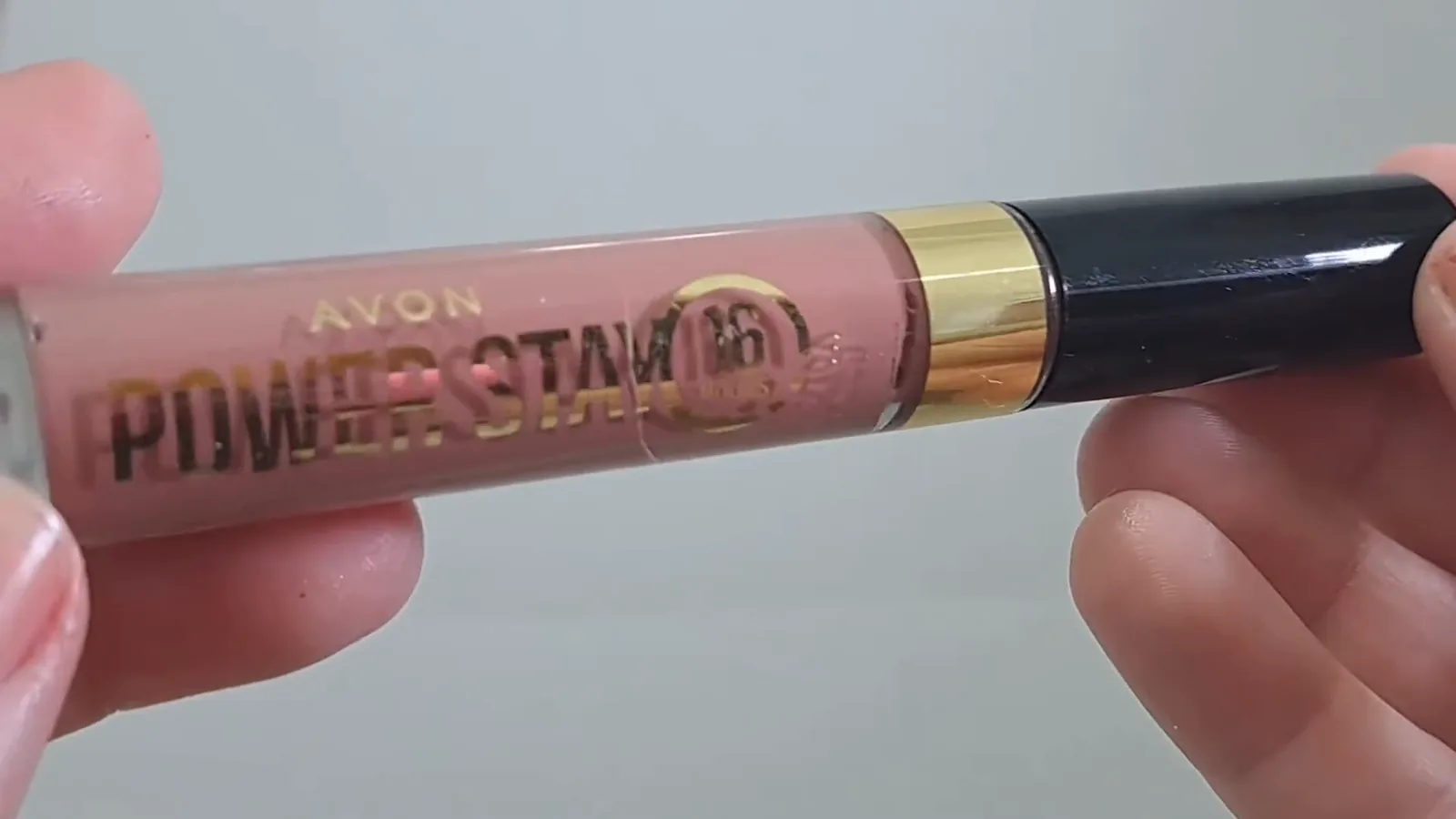 Frasco do batom líquido Avon Power Stay em mãos