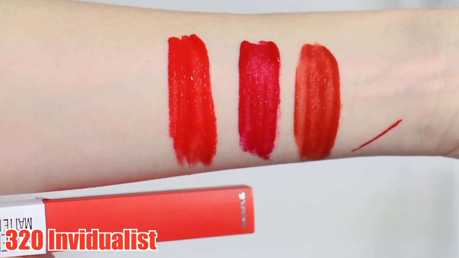 Frasco do batom matte Maybelline próximo aos swatches no braço