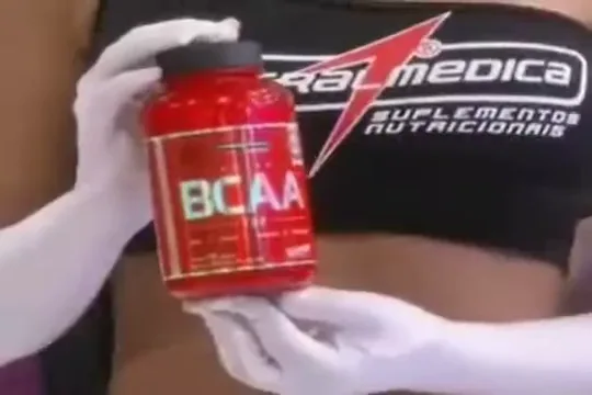 Frasco de BCAA Top Integralmedica segurado em apresentação de suplementos