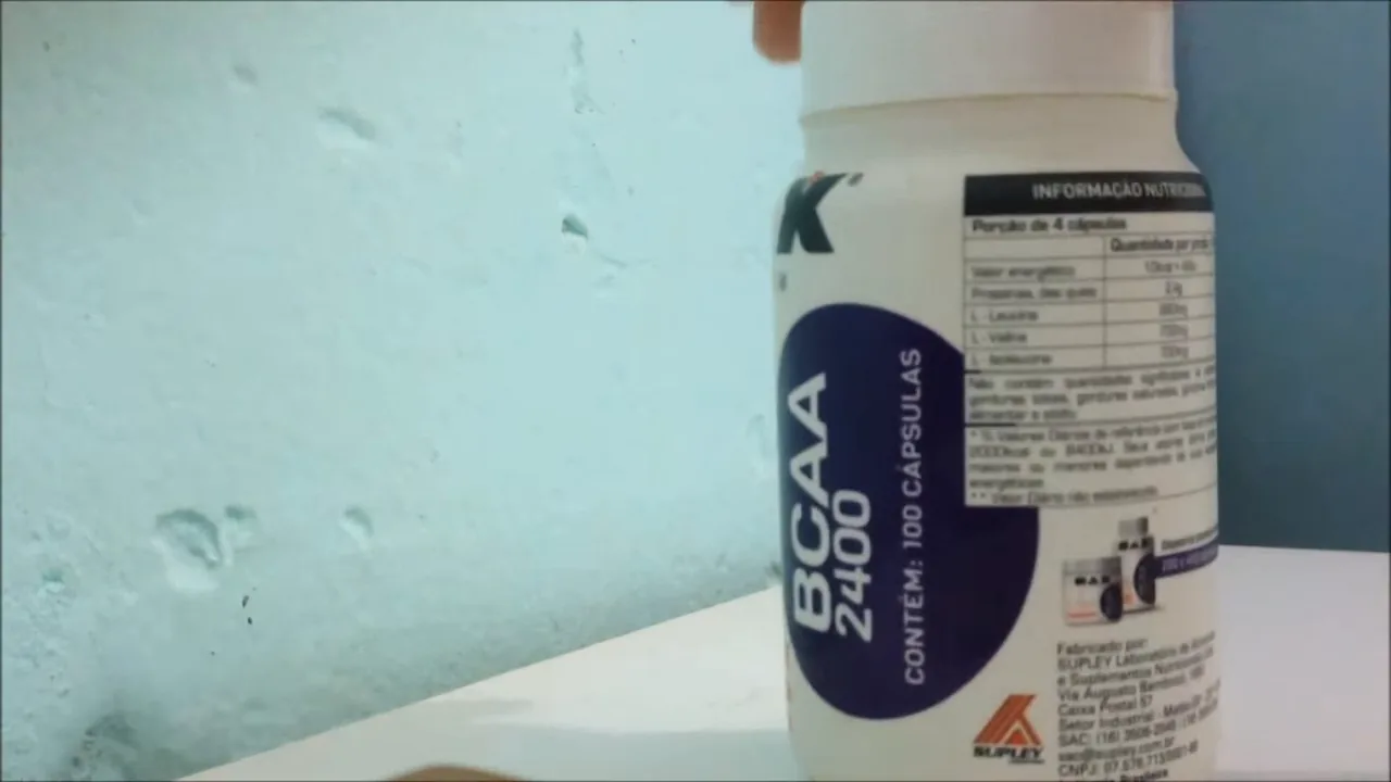 Manuseio do frasco de BCAA Max Titanium mostrando o verso