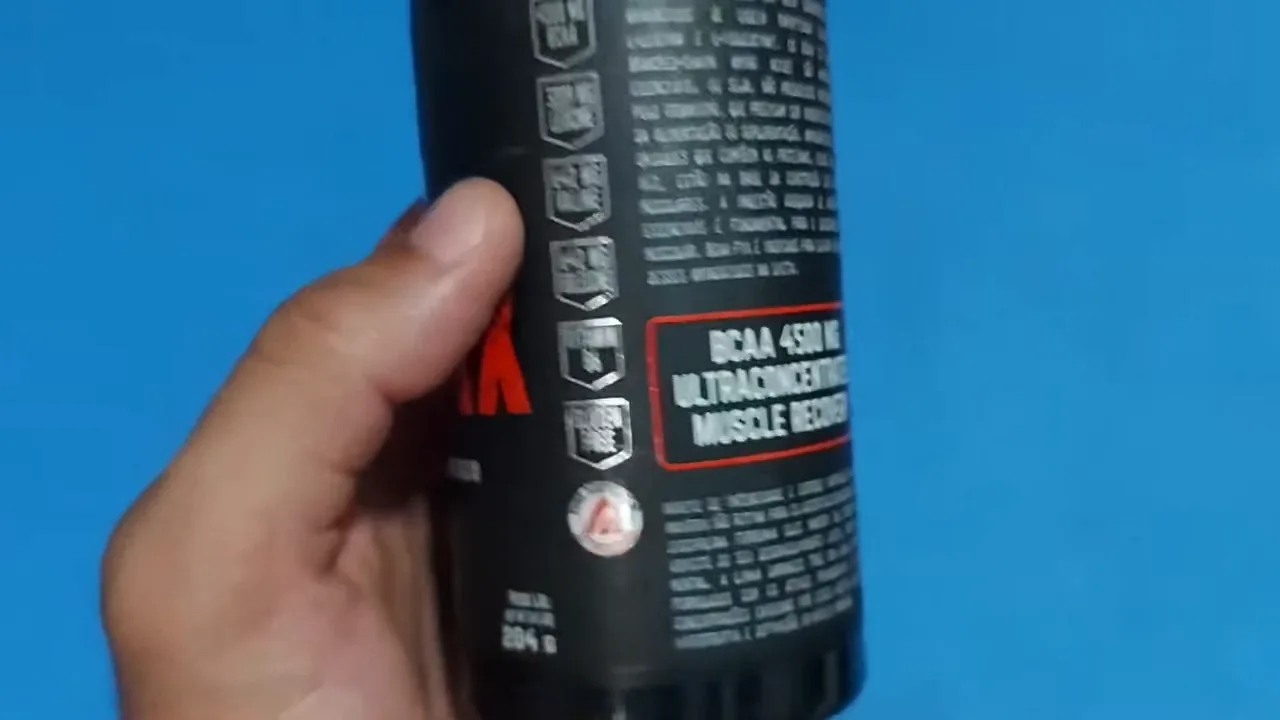 Manuseio do frasco exibindo a concentração de aminoácidos do suplemento