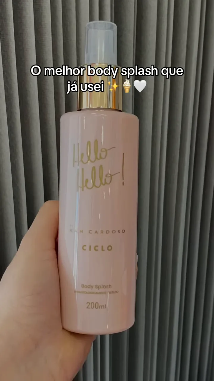 Frasco do body splash Hello Hello sendo segurado na mão