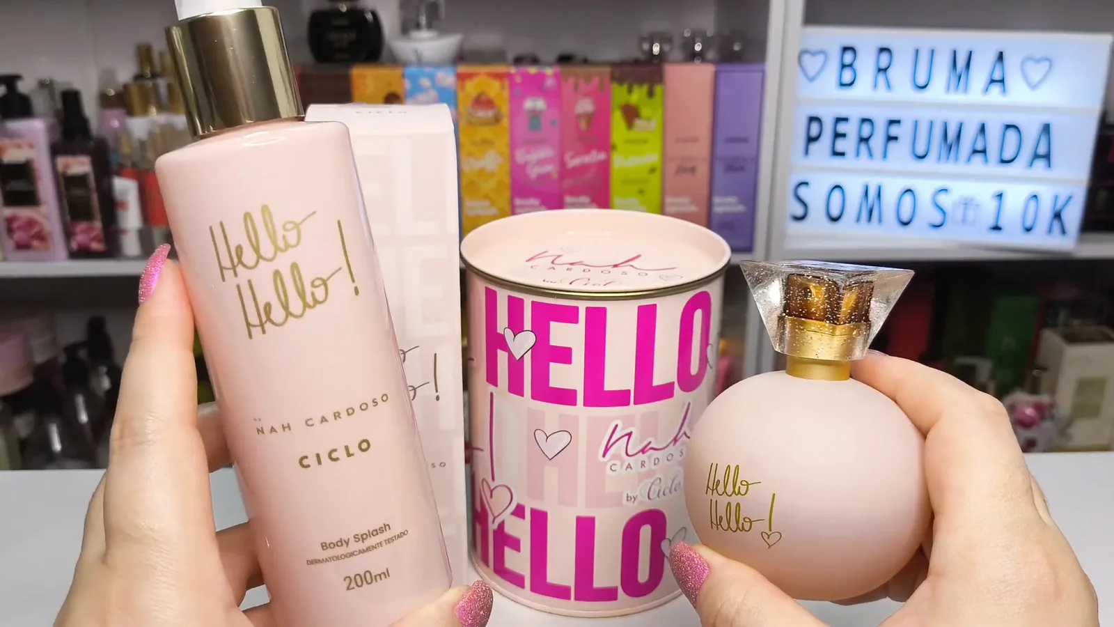 Frasco do body splash Hello Hello Ciclo segurado em mãos