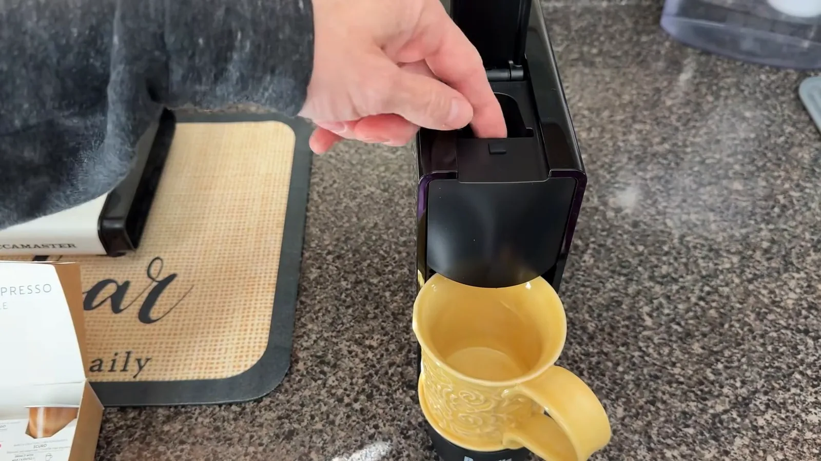 Inserção da cápsula de café no compartimento superior da cafeteira