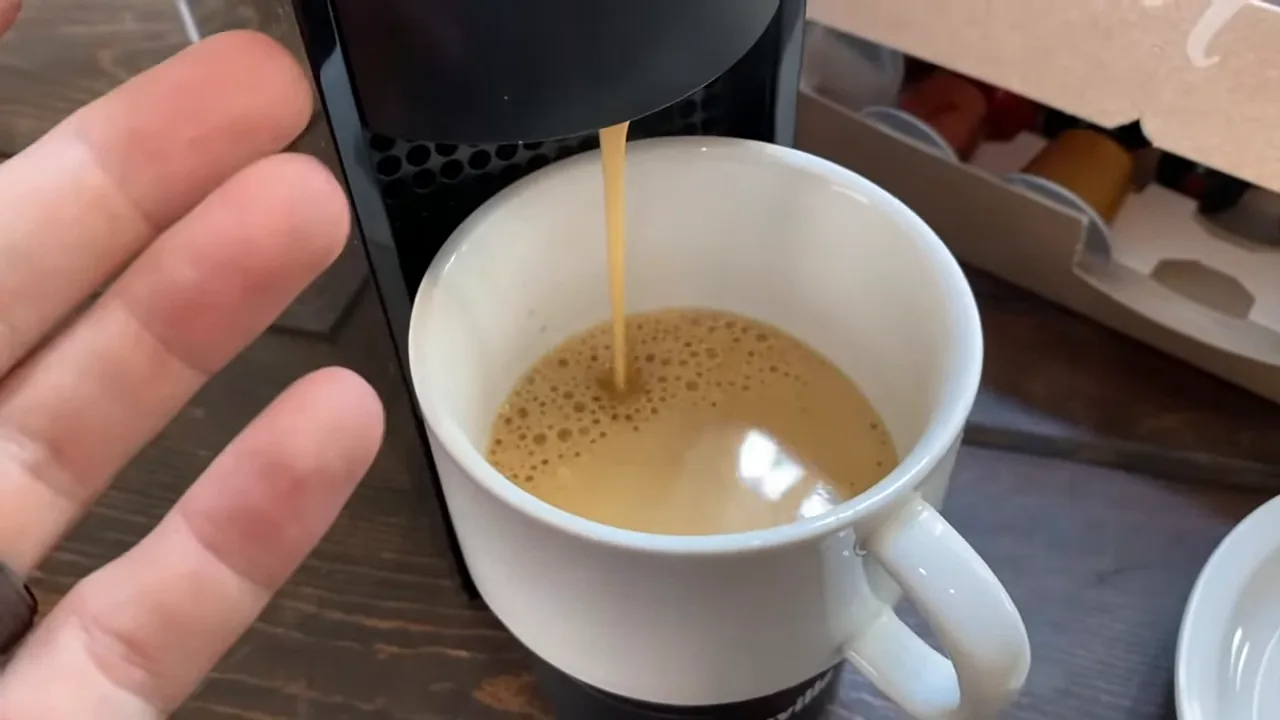 Cafeteira Nespresso Essenza Mini extraindo espresso com crema abundante na xícara