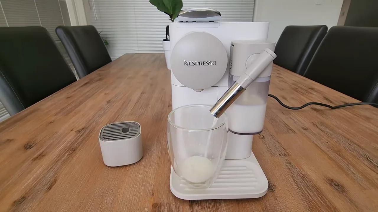 Cafeteira vaporizando e dispensando leite fresco diretamente no copo