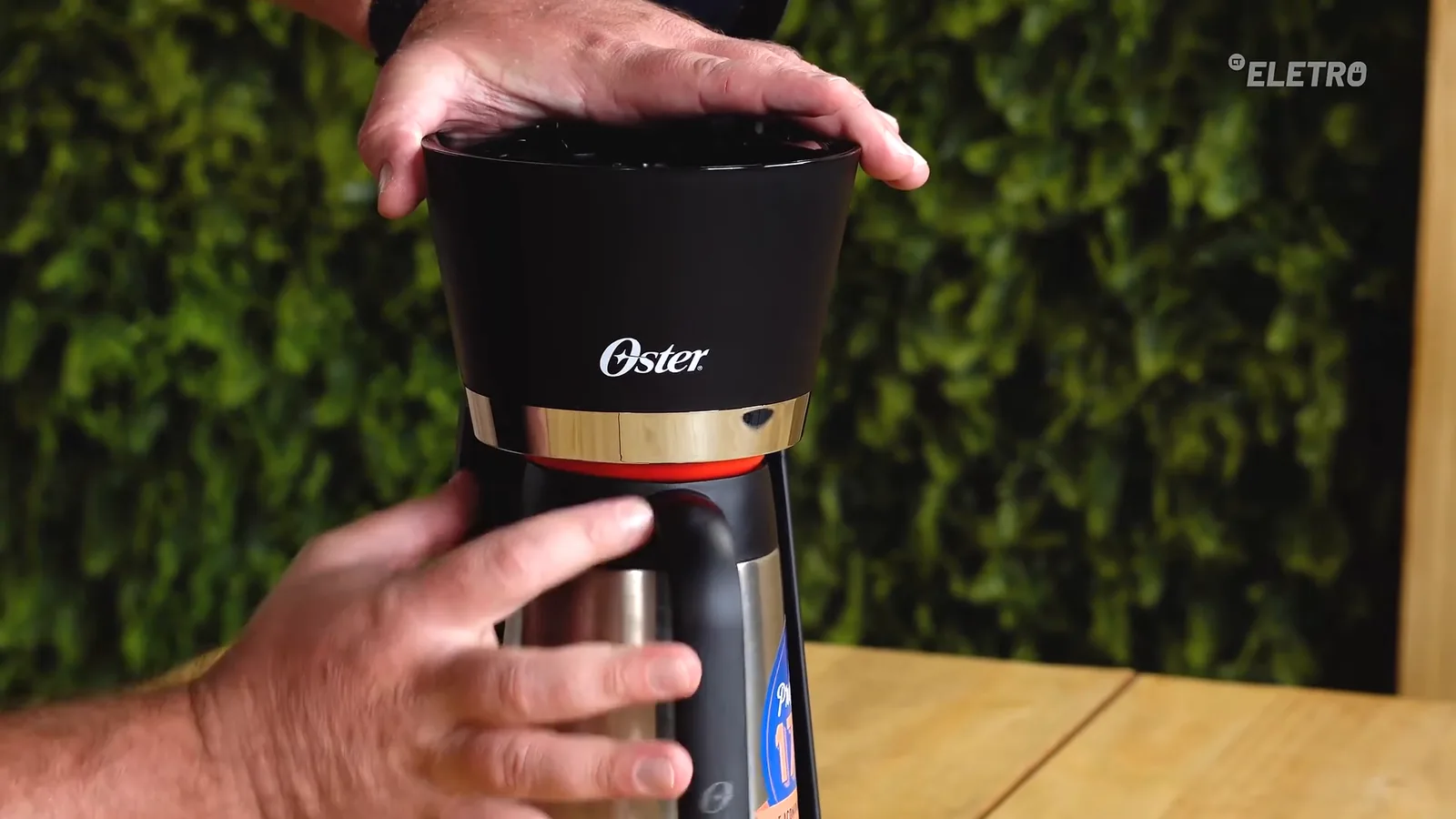 Jarra de inox sendo encaixada na cafeteira Oster Black