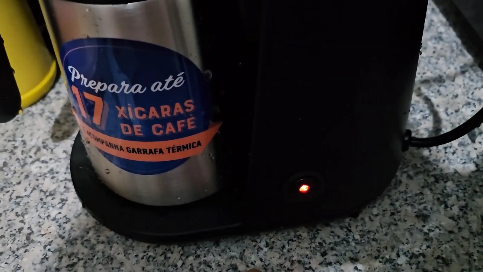 Cafeteira elétrica ligada na bancada com luz indicadora acesa