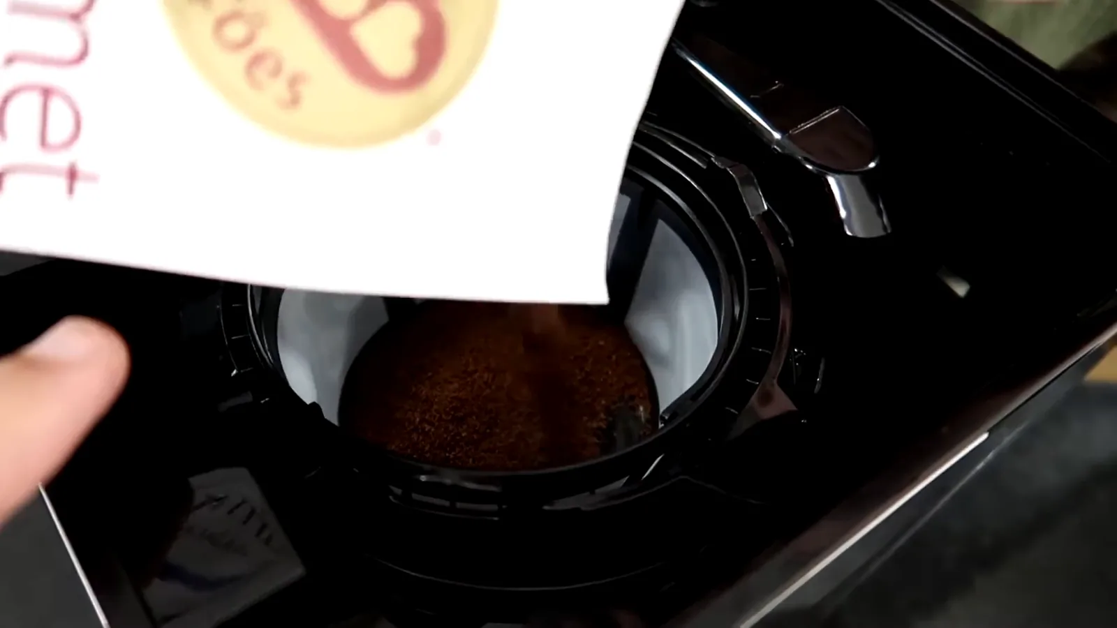 Filtro permanente da cafeteira sendo abastecido com pó de café