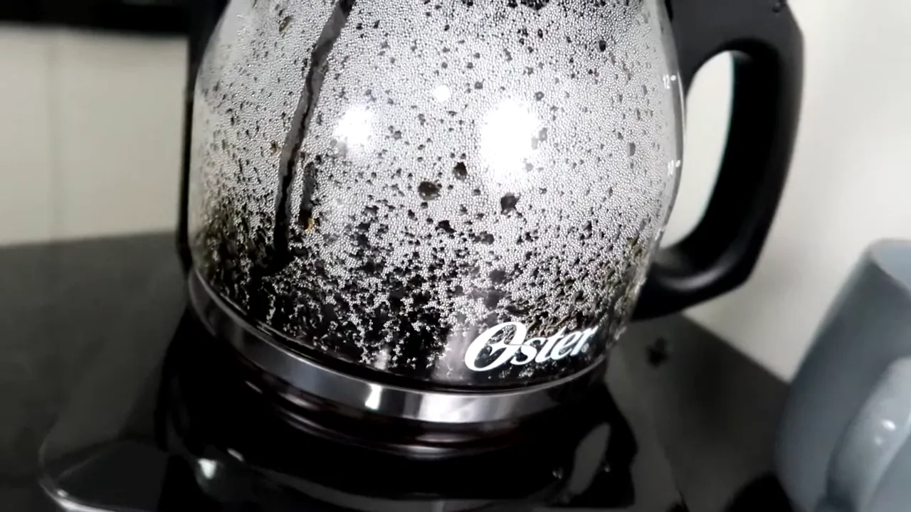 Café passado gotejando na jarra de vidro da cafeteira