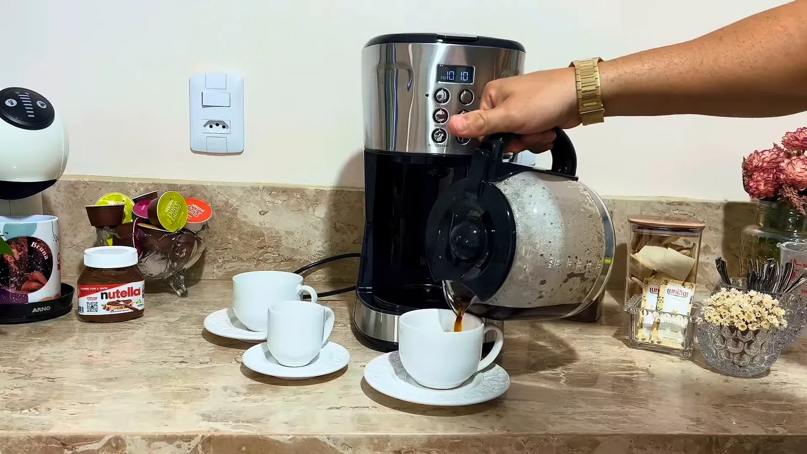 Servindo xícara de café fresco com a jarra da cafeteira