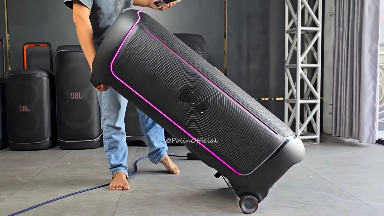 JBL PartyBox Ultimate sendo movimentada sobre rodas com iluminação ativa