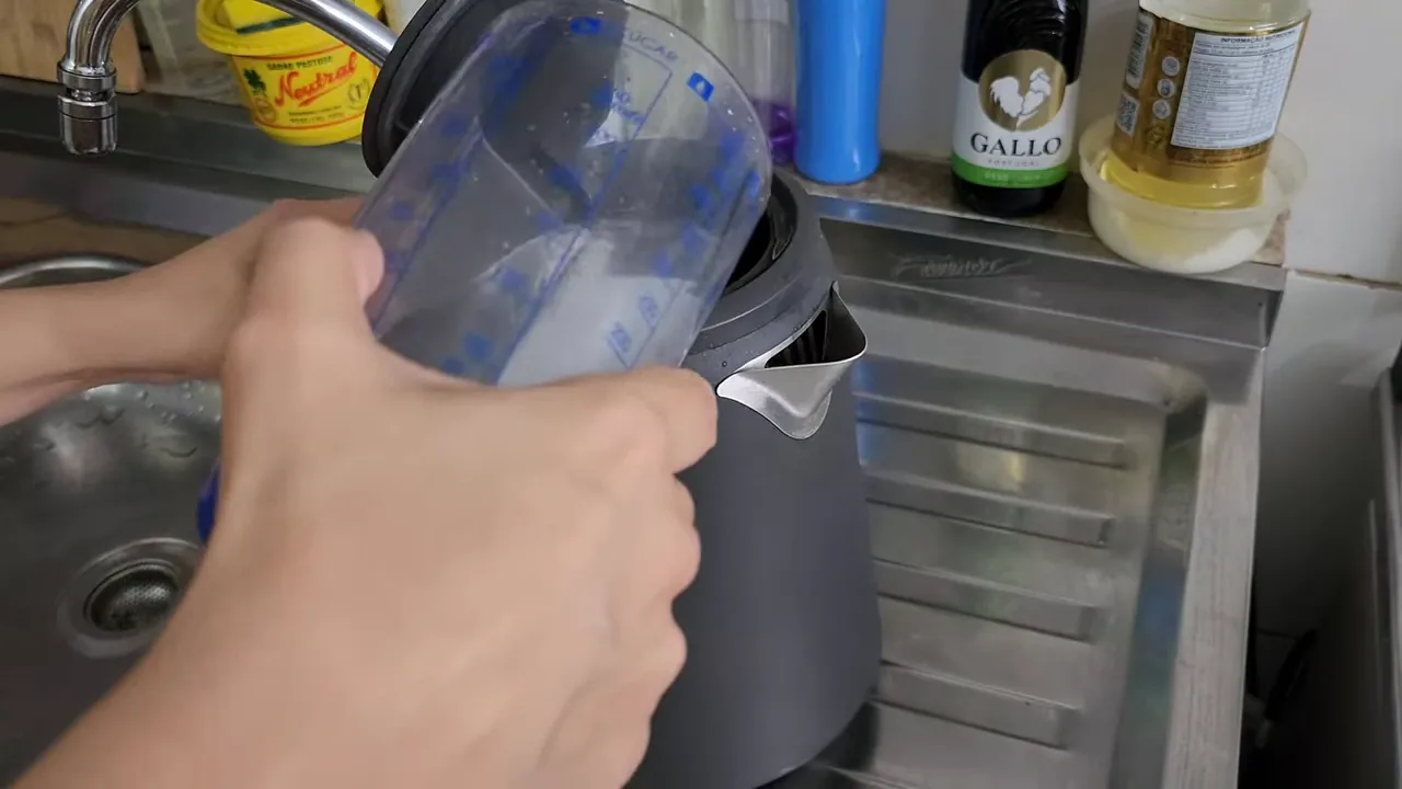 Abastecendo a chaleira elétrica com água através da tampa articulada