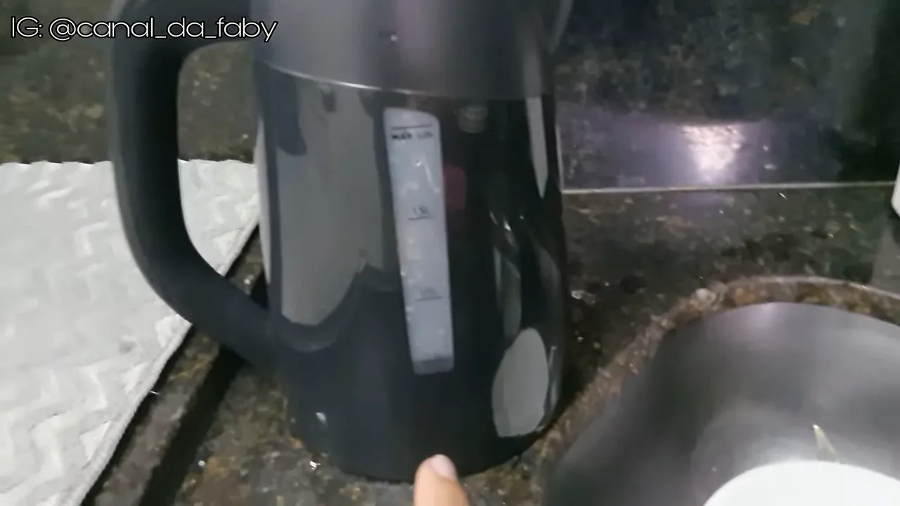 Água sendo adicionada na chaleira com medição pelo visor transparente