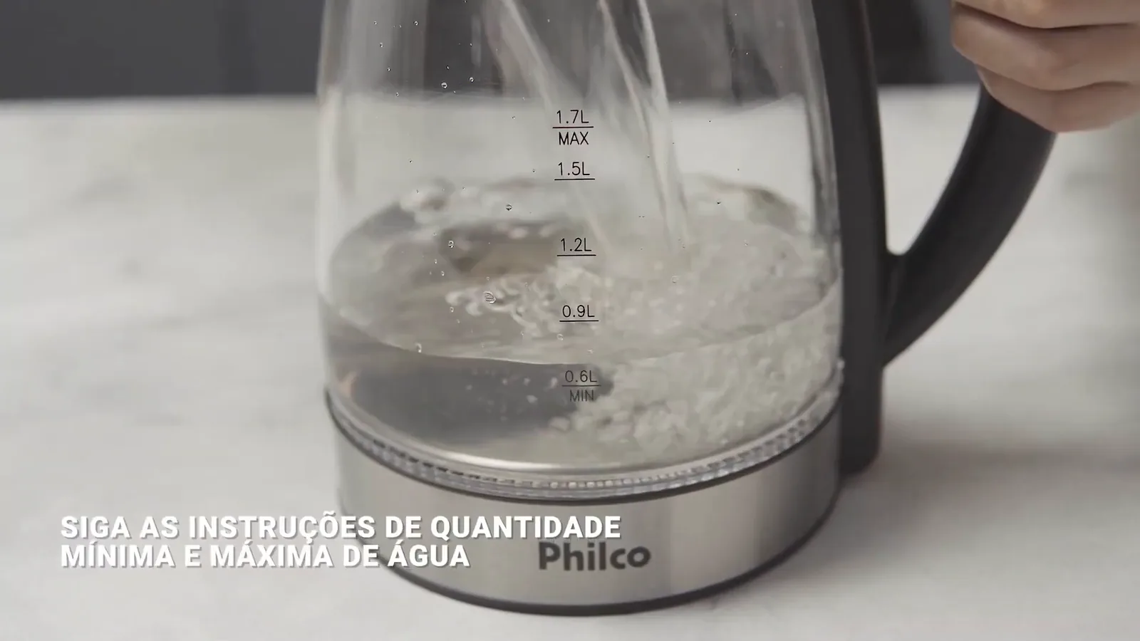 Jarra de vidro sendo abastecida com água na bancada