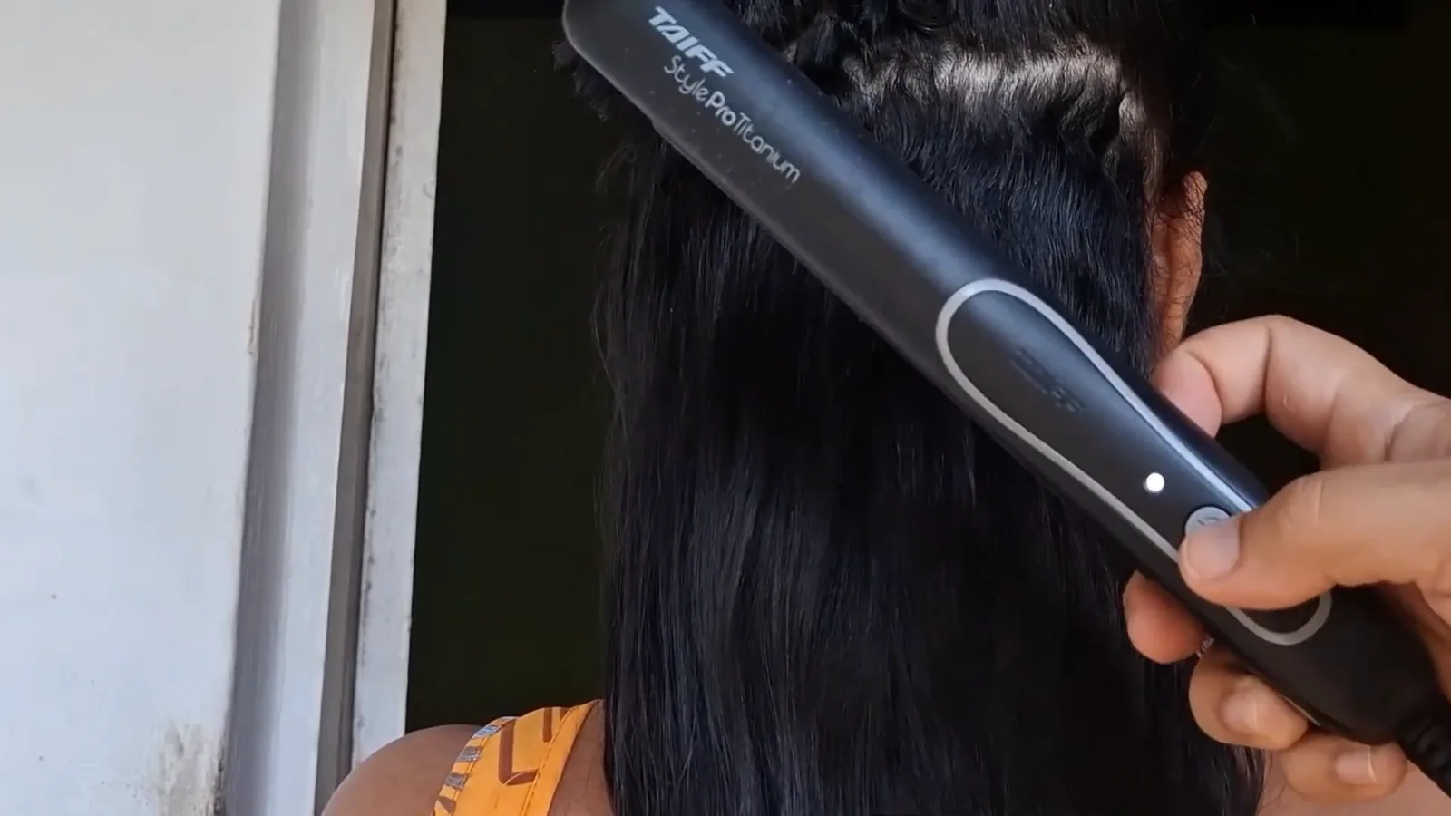 Prancha Taiff Style Pro alisando mecha de cabelo escuro
