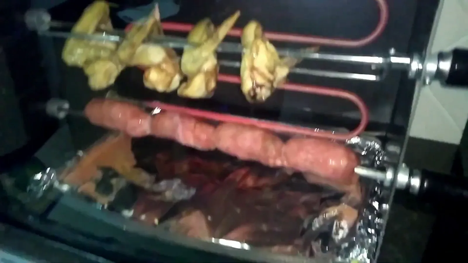 Frango e linguiças sendo assados uniformemente na churrasqueira elétrica Arke