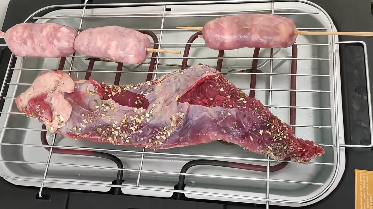 Churrasqueira elétrica assando carne e linguiças na grelha cromada