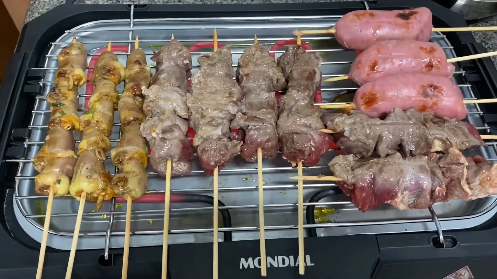 Churrasqueira elétrica Mondial assando diversos espetinhos de carne e linguiça