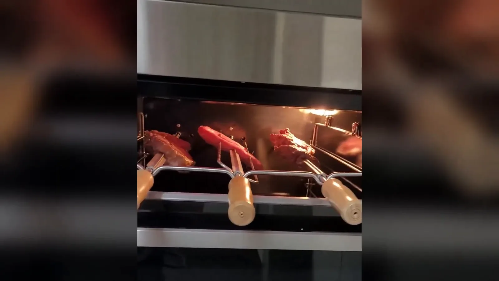 Churrasqueira elétrica de embutir assando carnes em três espetos rotativos