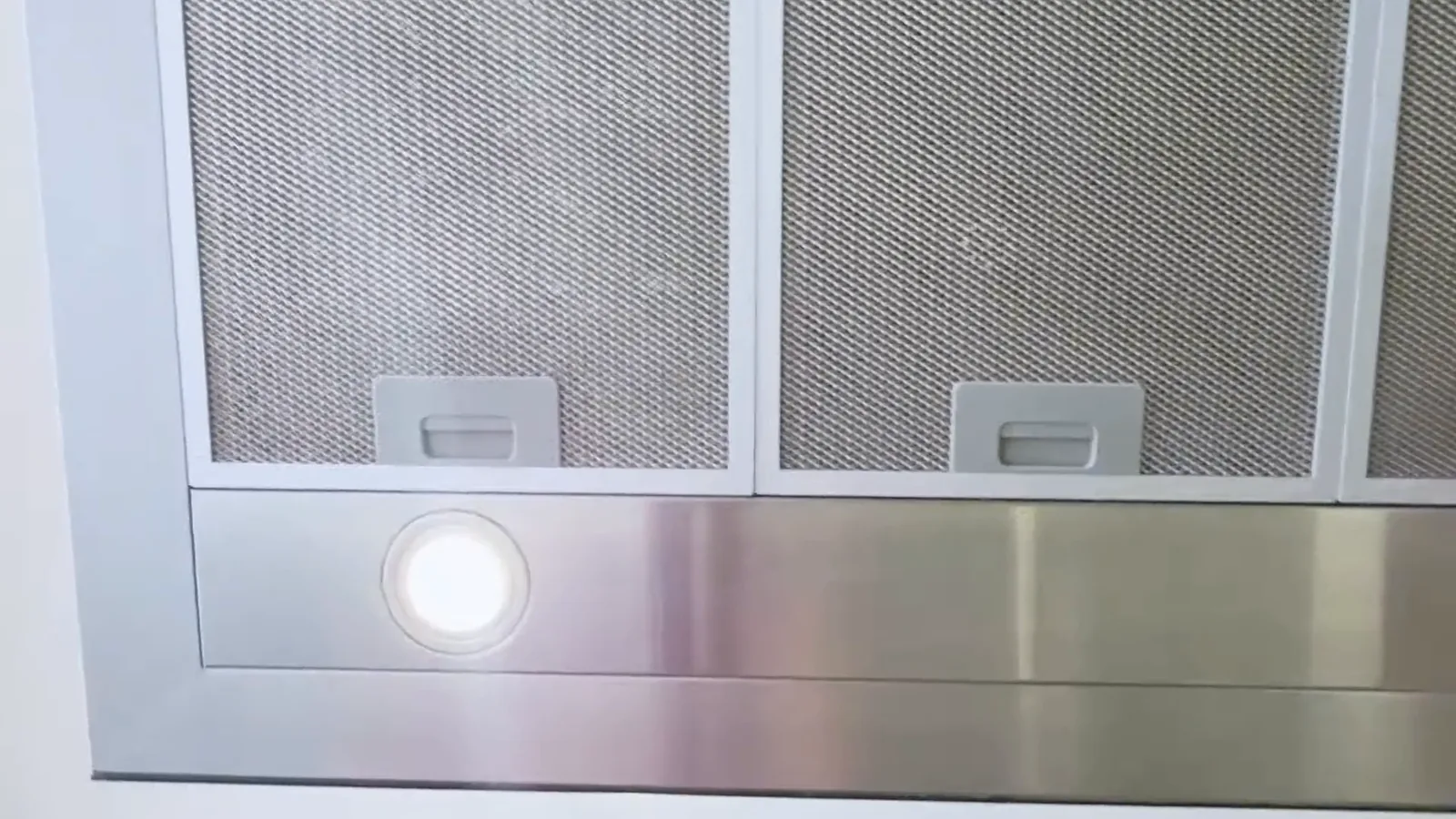 Base inferior da coifa com luzes LED acesas e filtros metálicos