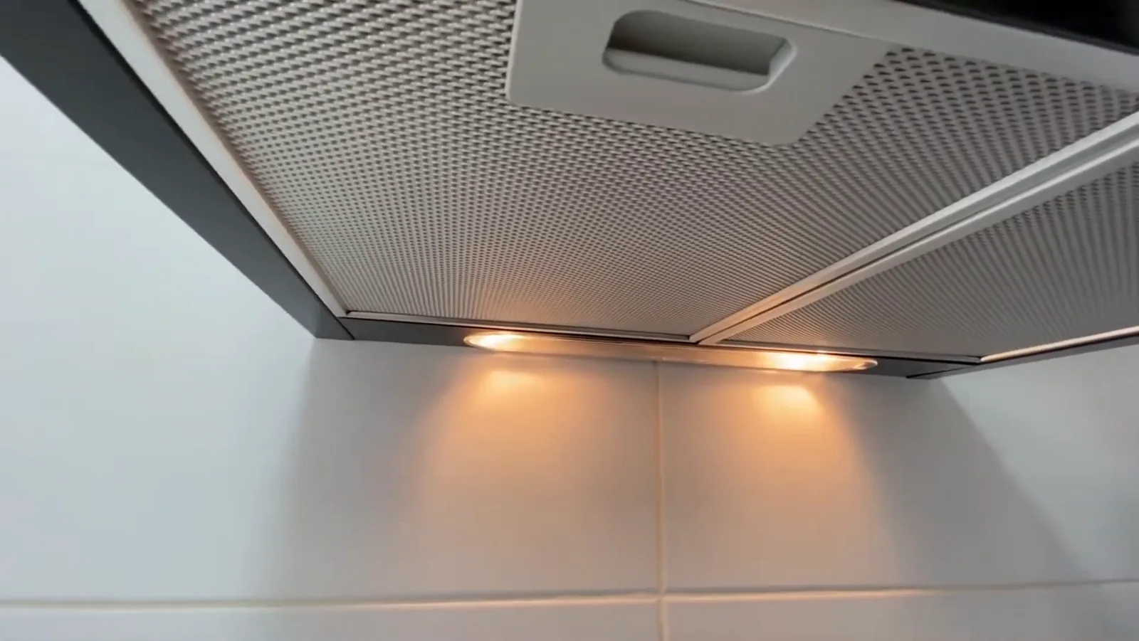 Lâmpadas acesas e filtros metálicos inferiores da coifa Brastemp instalada