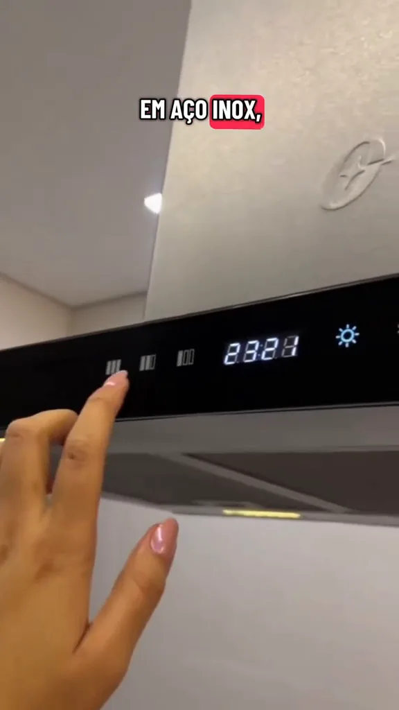 Painel digital touch control da coifa Oster sendo ajustado manualmente