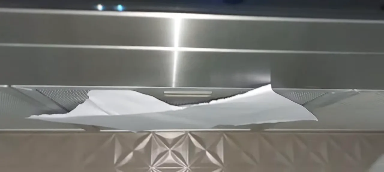 Teste de sucção da coifa Fischer prendendo papel na grelha metálica