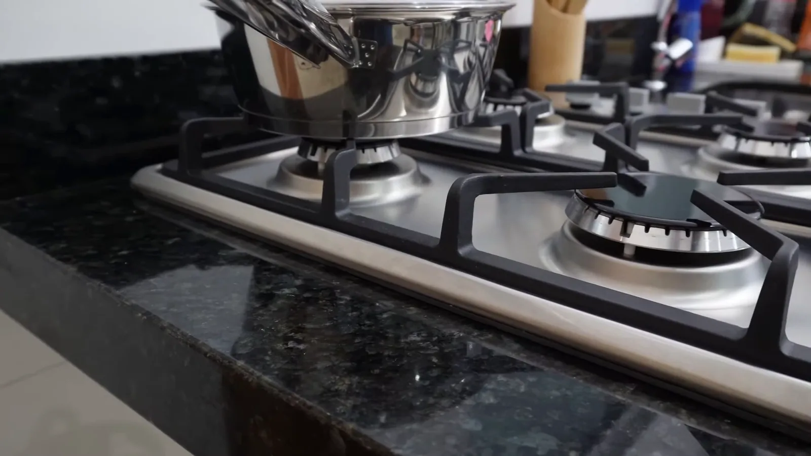 Panela aquecendo sobre trempe com chama acesa no cooktop Philco