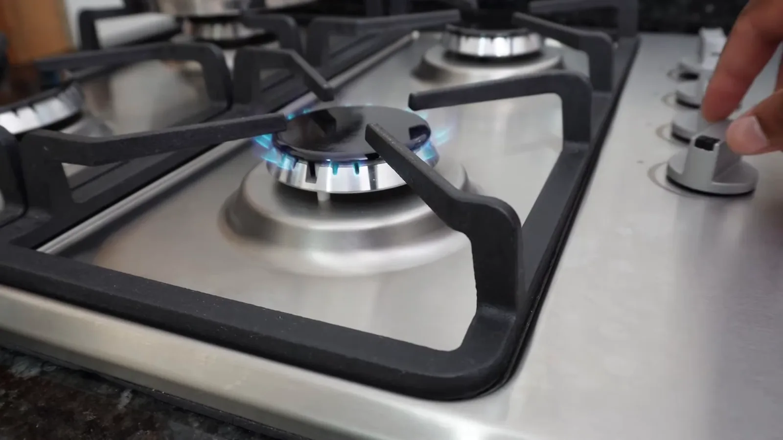 Chama azul acesa com regulagem precisa no cooktop de inox